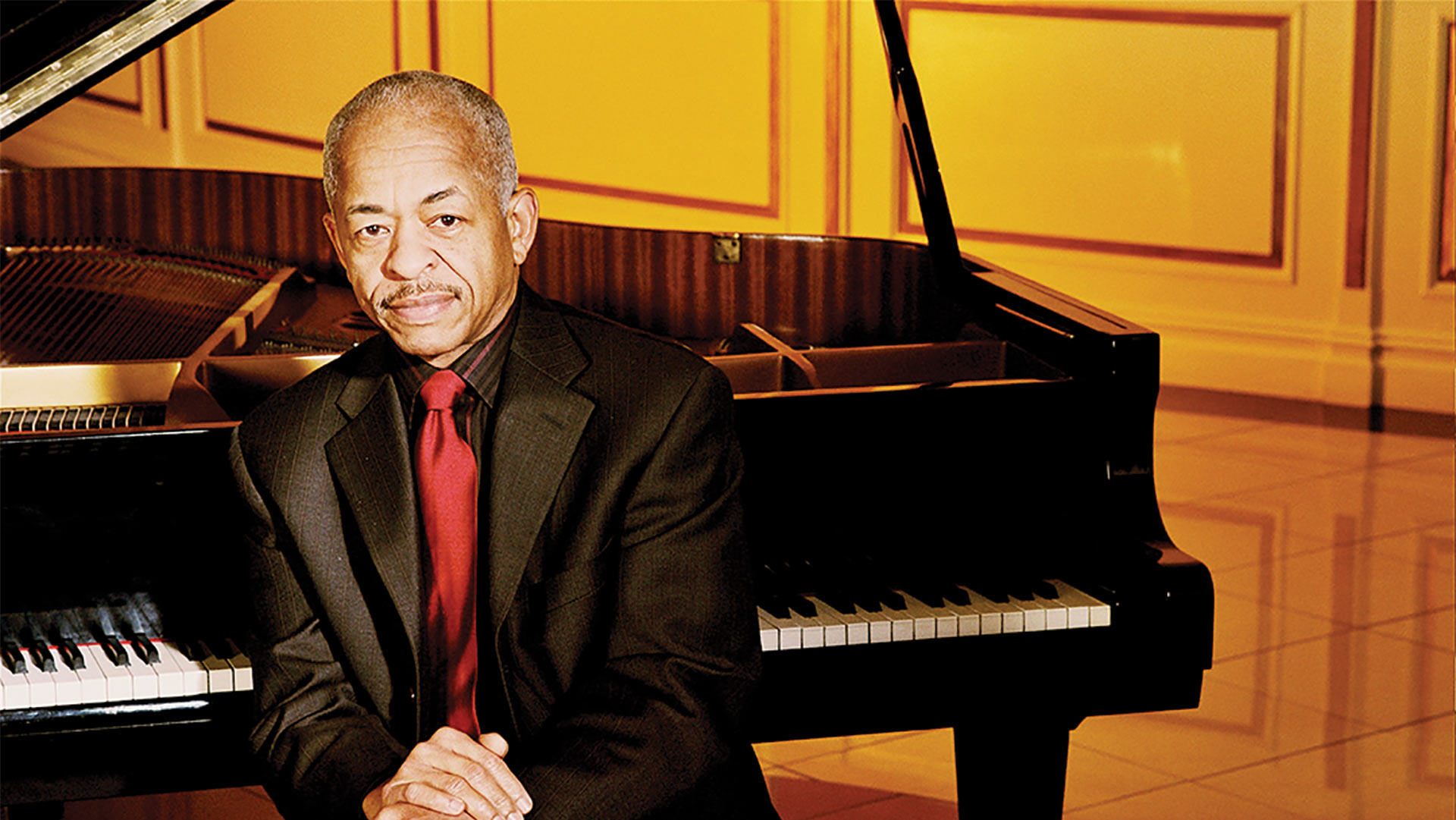 Adegoke Steve Colson seated at a grand piano