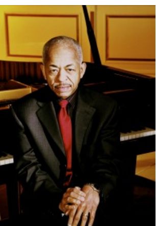 Adegoke Steve Colson seated at a piano, from Penn Ar Jazz